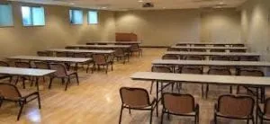 Multipurpose room with a wood floor set up with tables and chairs