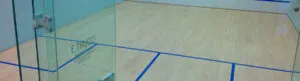 Glass-back squash court with a maple floor and blue court lines