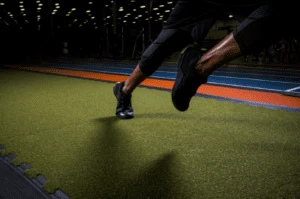 Athlete sprinting on green indoor turf in a training facility