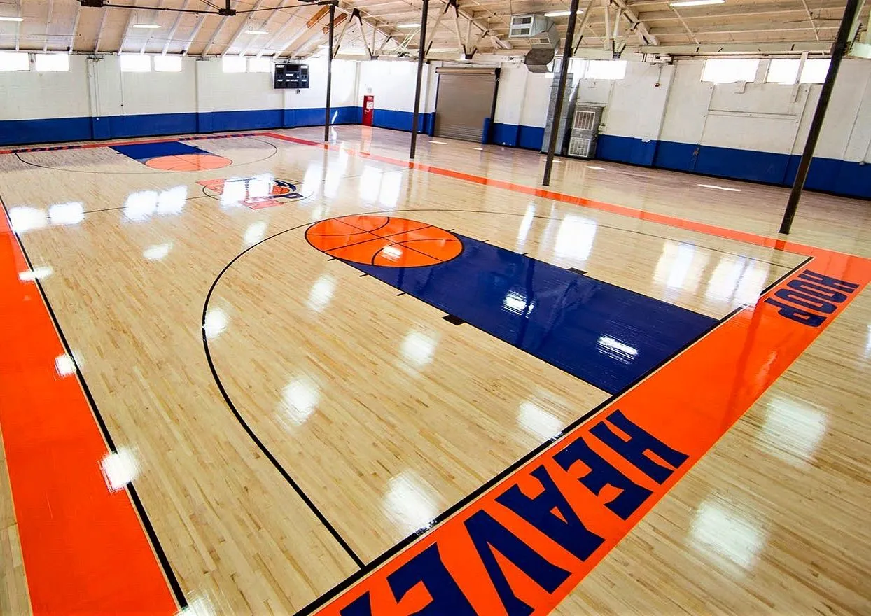 Glossy maple gym floor with orange and navy painted lanes and lettering