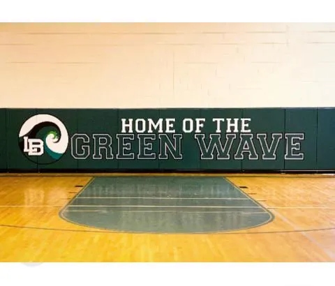 Green Home of the Green Wave printed wall pad above a maple floor with a green painted key