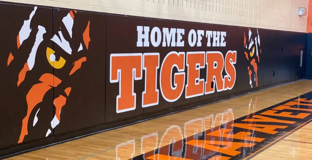 Black and orange Home of the Tigers printed gym wall pads with tiger claw graphics