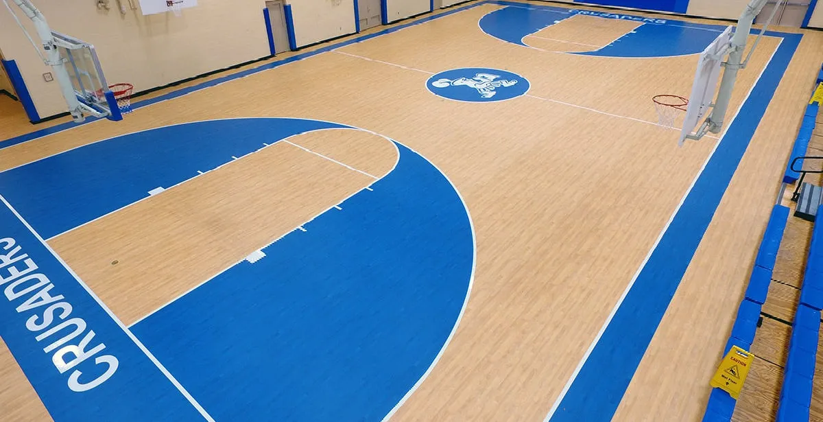 Multi-sport gym floor with blue keys, a blue border and CRUSADERS lettering