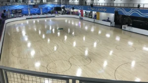 Refinished maple roller skating rink floor with painted swirl circles and center logo at The Arenas at Woodbridge, NJ