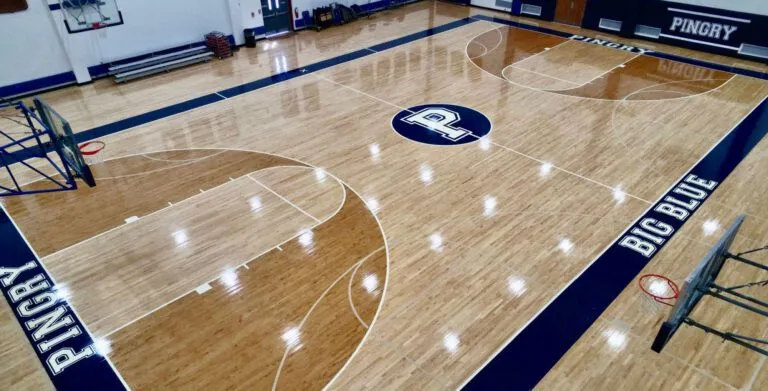 Pingry School maple gym floor with navy BIG BLUE border lettering and a P center logo