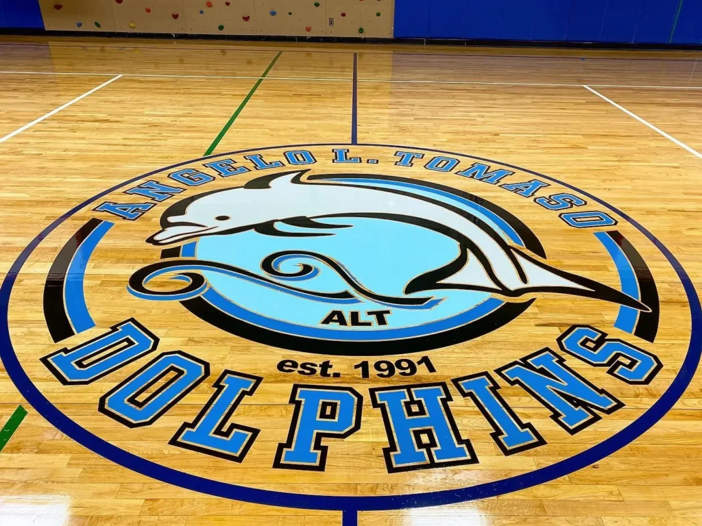 Angelo L. Tomaso School Dolphins center court logo painted on a maple gym floor