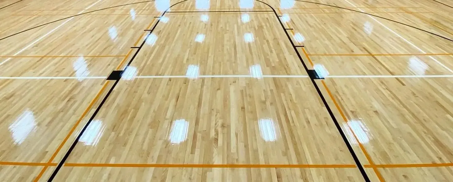 Maple gym floor with black, white and orange game lines for more than one sport