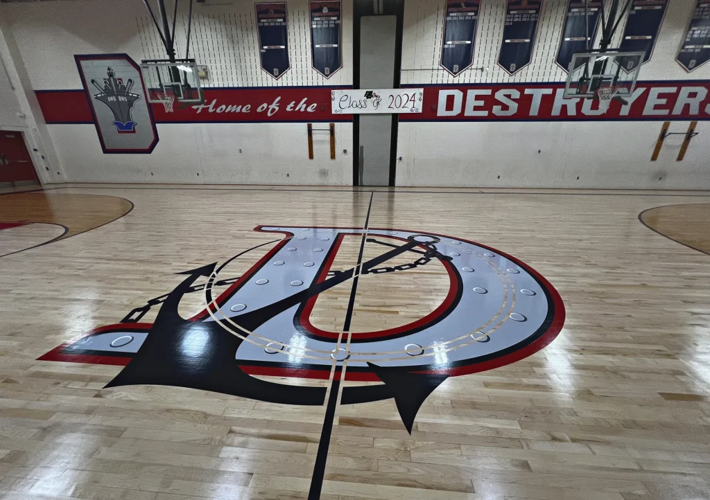 Dunellen Destroyers home gym in Dunellen NJ after J and J Gym Floors resurfaced the maple floor, with a red, navy and silver anchor D center logo