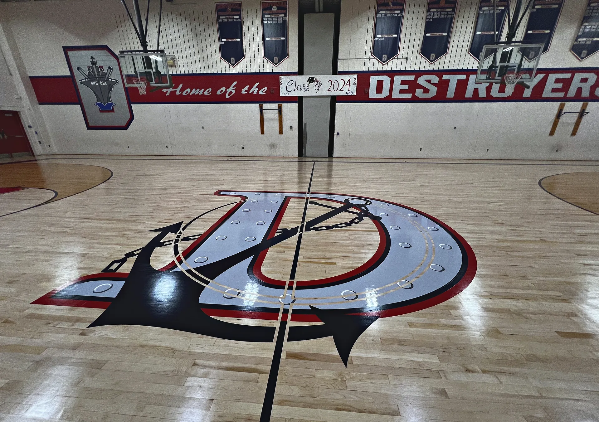 Dunellen Destroyers home gym in Dunellen NJ after J and J Gym Floors resurfaced the maple floor, with a red, navy and silver anchor D center logo