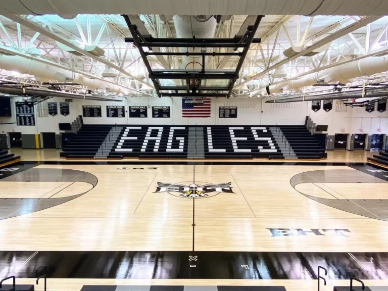 Glossy finished maple gym floor with EAGLES lettering on the bleachers