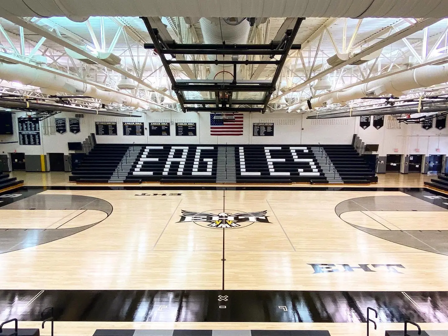 Glossy finished maple gym floor with EAGLES lettering on the bleachers