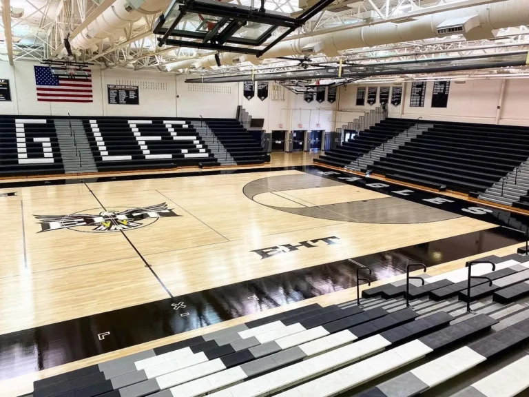 High-gloss finished maple gym floor in the EHT Eagles gym, with EAGLES lettering on the bleachers