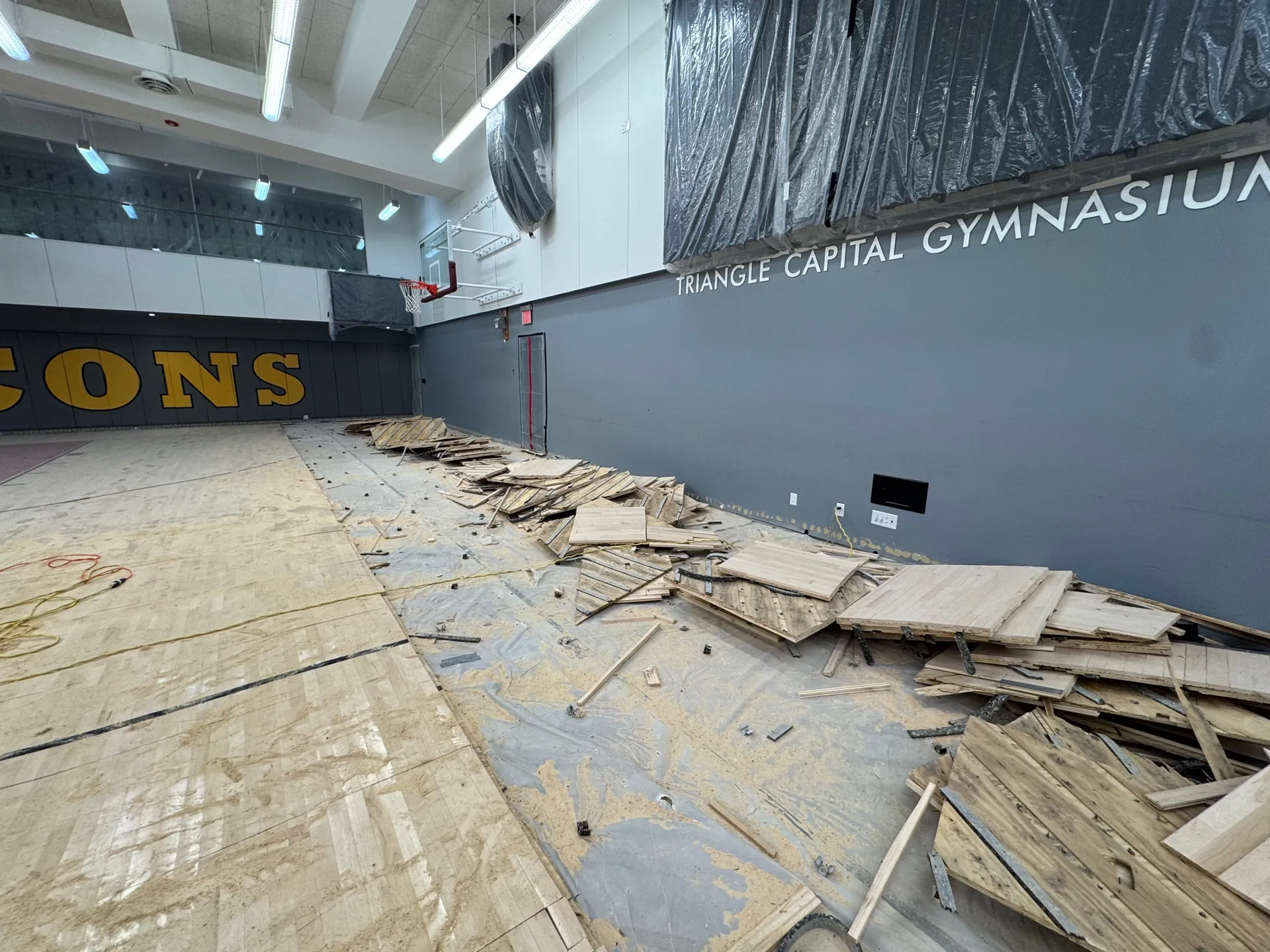 During: the old Falcons gym floor torn out, with boards piled on the slab