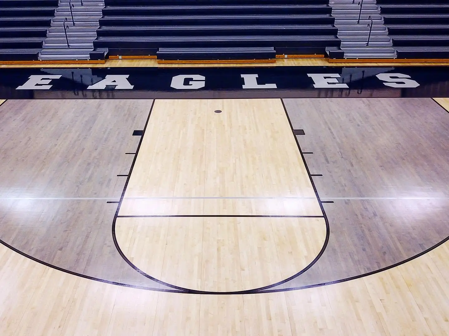 Glossy maple gym floor key and game lines with EAGLES sideline lettering