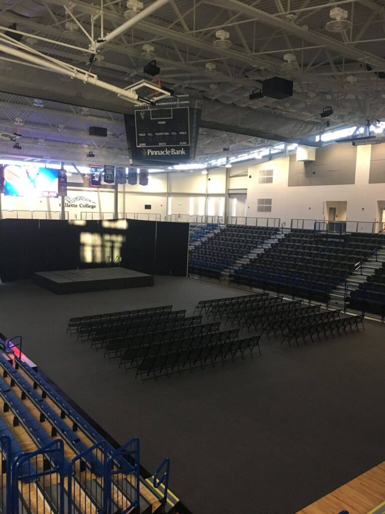Gym floor cover tiles protecting an arena floor set up with chairs and a stage