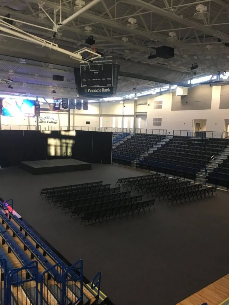 Gym floor cover tiles protecting an arena floor set up with chairs and a stage