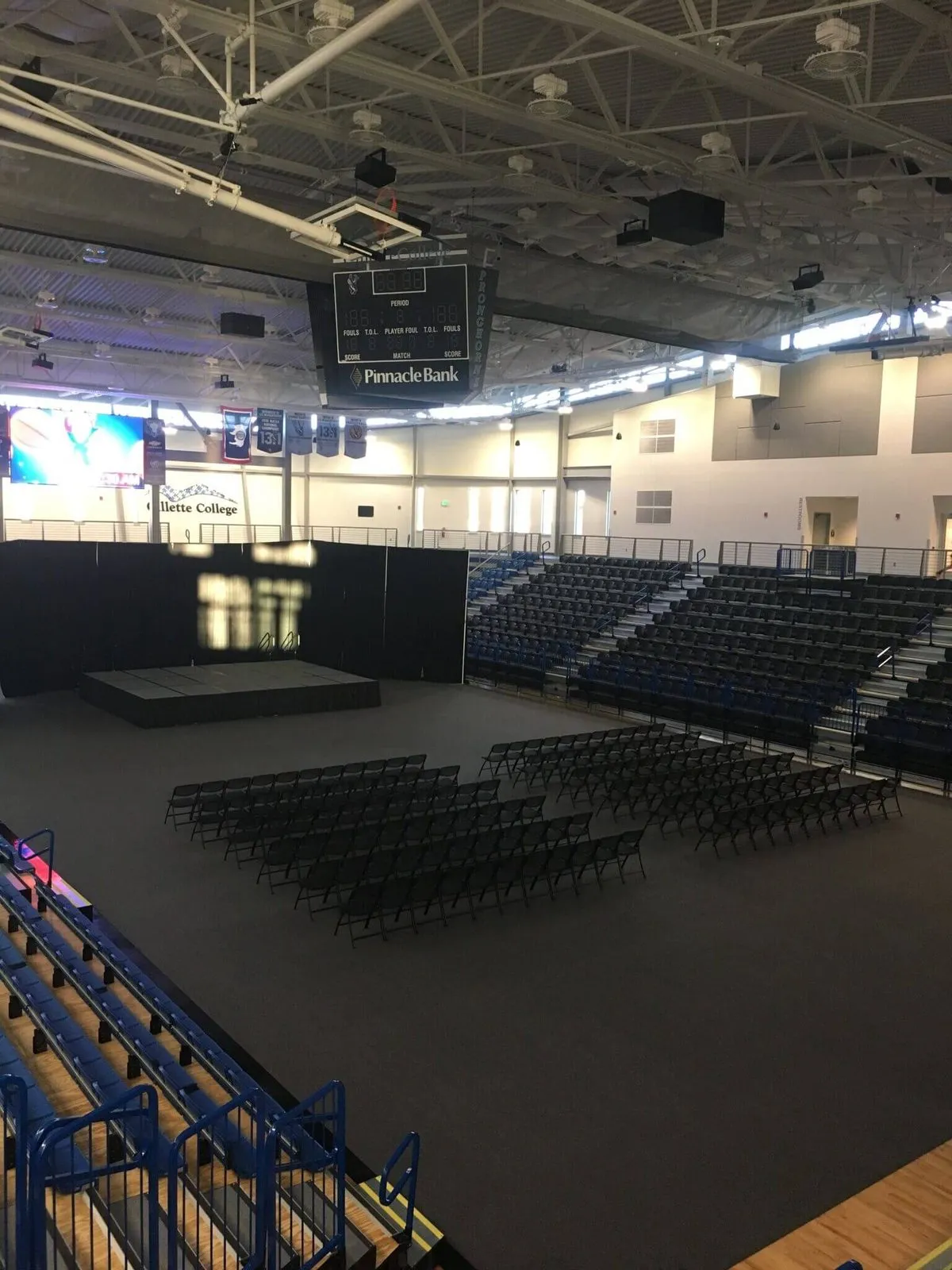 Gym floor cover tiles protecting an arena floor set up with chairs and a stage
