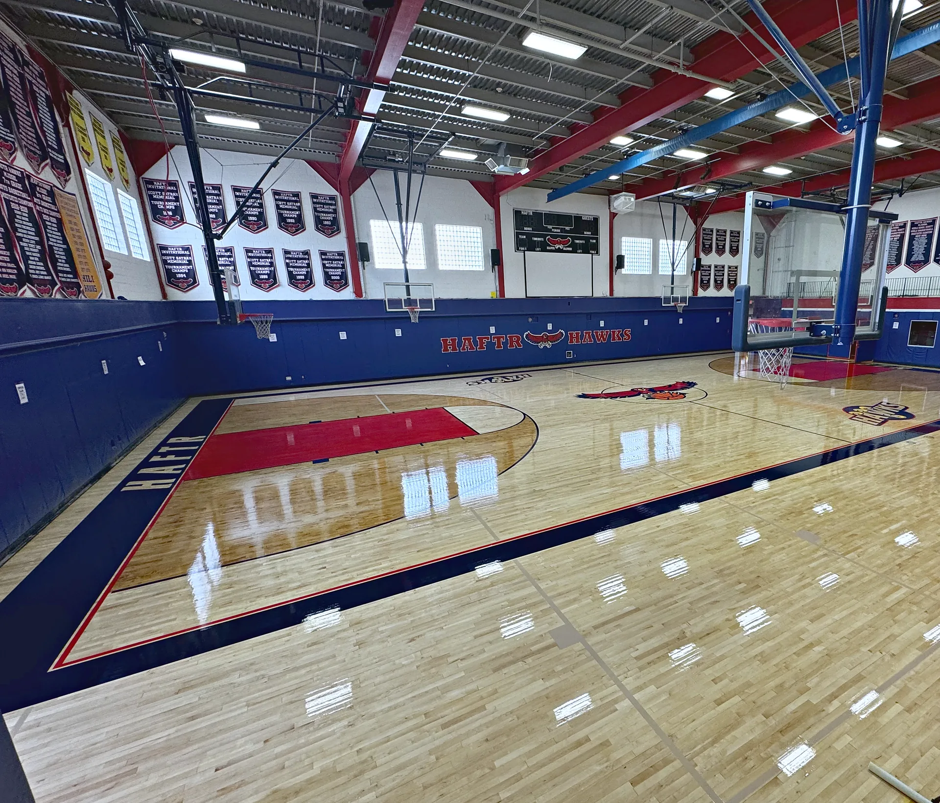 HAFTR Hawks main gym in Lawrence NY after a sand and refinish by J and J Gym Floors: maple floor with red key, stained three-point areas and navy and red border