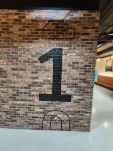 Large black number 1 graphic applied over a brick wall