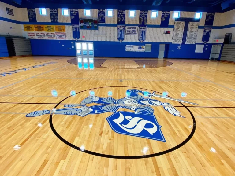 Light blue and navy S center court logo on a glossy maple gym floor