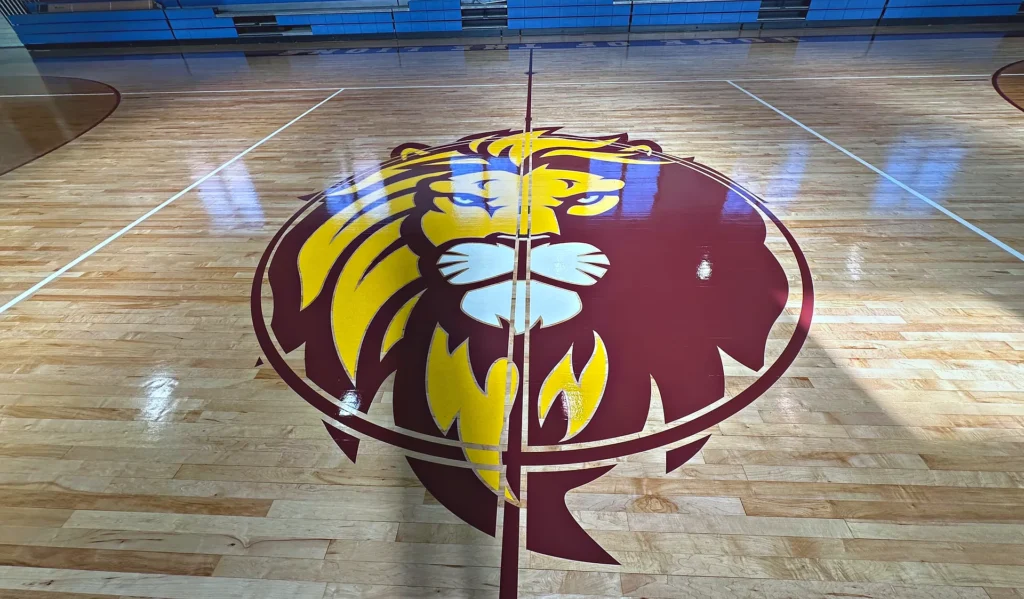 Marlboro maroon and gold lion center-court logo painted on a high-gloss maple gym floor