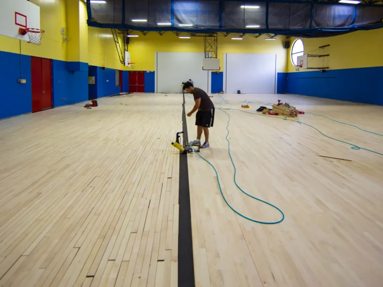 J and J installer working on a newly laid maple gym floor before sanding and finish