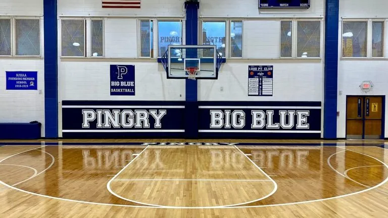 Glossy Pingry School basketball court with navy Pingry Big Blue wall pads