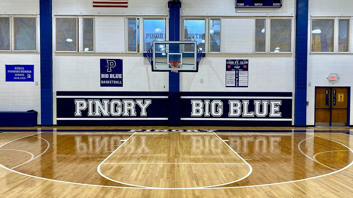 Glossy Pingry School basketball court with navy Pingry Big Blue wall pads
