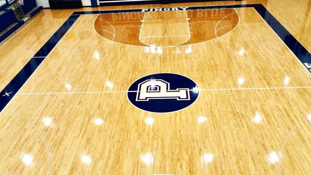 Refinished Pingry School gym floor with navy center circle and white P logo
