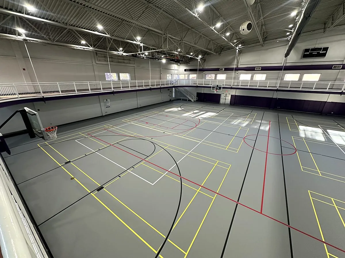 Gray poured rubber multi-sport gym floor with yellow, red, black and white game lines