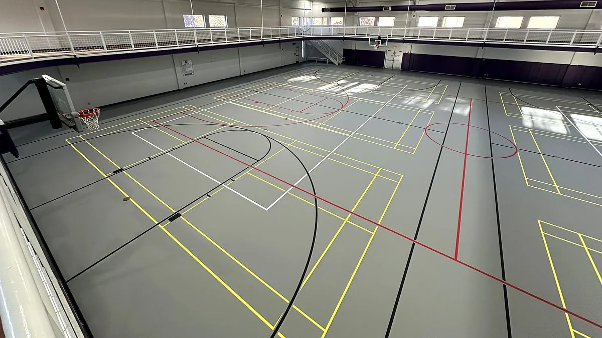 Gray poured rubber multi-sport gym floor with yellow, red, black and white game lines