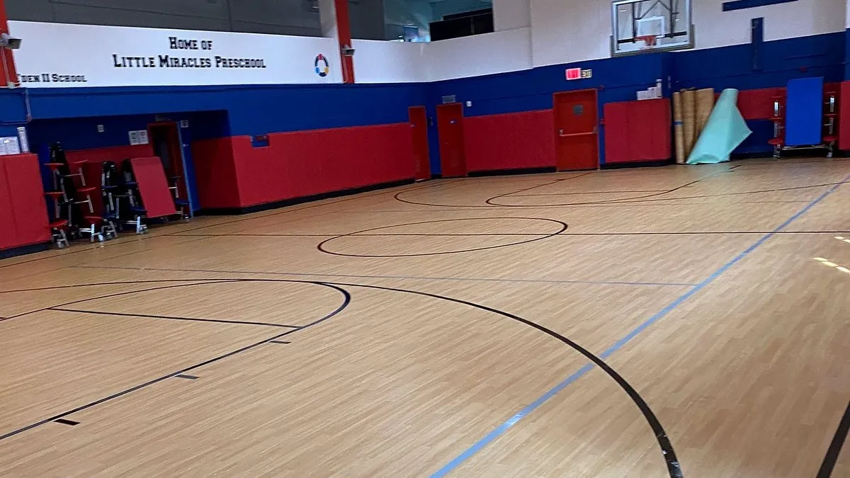 Rolled vinyl gym floor with wood-look surface and painted game lines in a New Jersey preschool gym