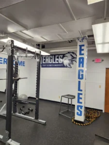 Saint Elizabeth University Eagles logo wall graphic and wrapped EAGLES column in a weight room