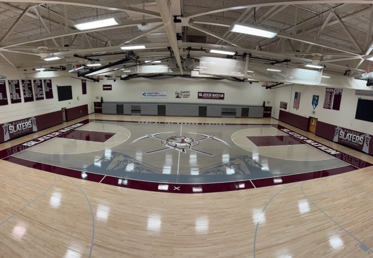 Panoramic view of the new maple gym floor at Bangor Area High School with gray and maroon stained keys