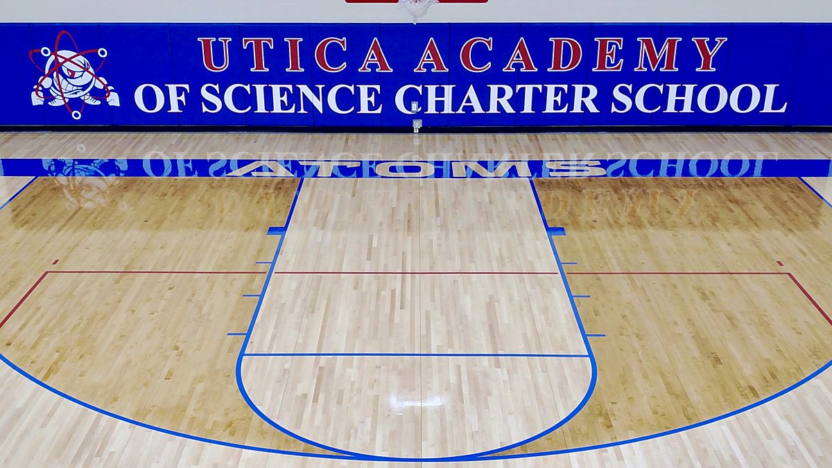 Utica Academy of Science gym floor with blue and red game lines and matching wall pads