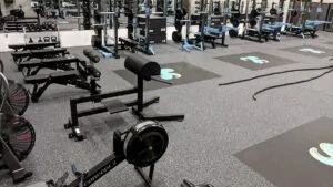Weight room with rubber floor, power racks and floor logos